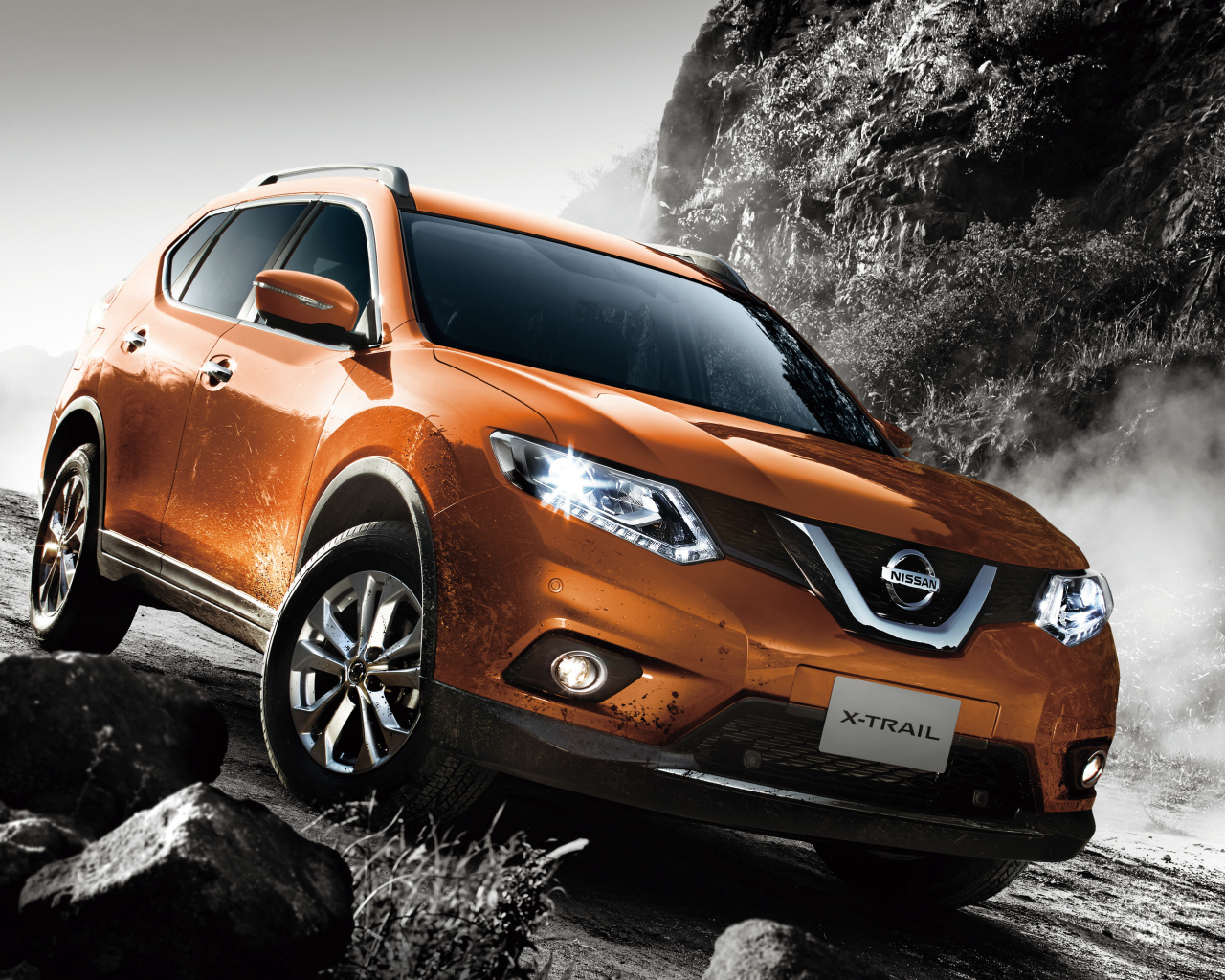 Оранжевый автомобиль Nissan X-Trail на размытой дороге 