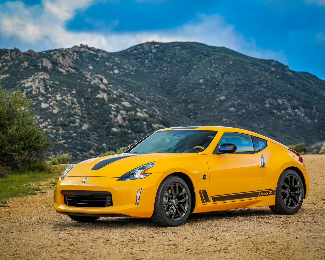 Желтый автомобиль Nissan 370Z Heritage Edition, 2018 на фоне гор