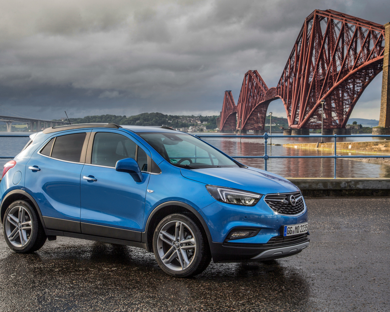 Синий автомобиль Opel Mokka у моста 