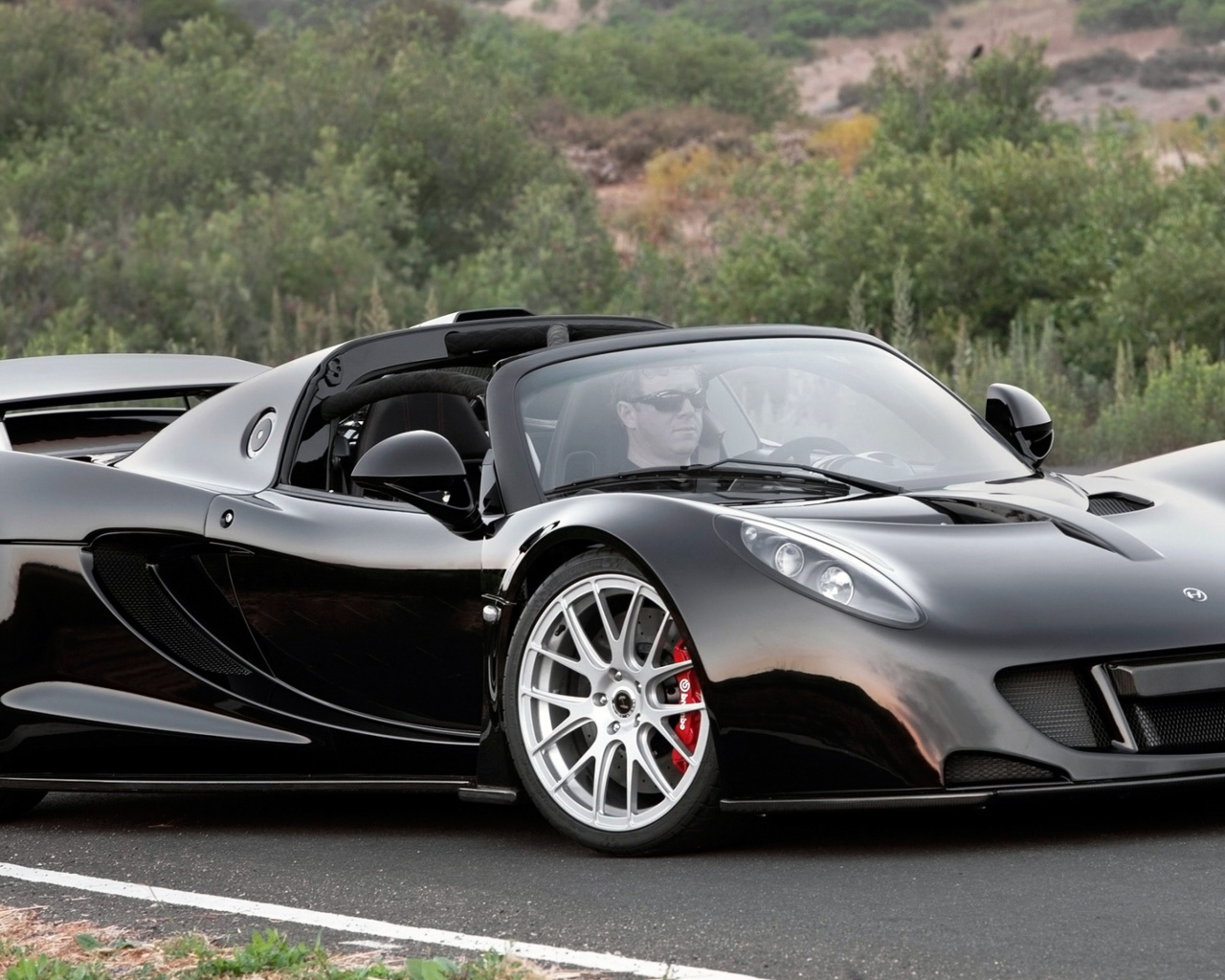 Черный спортивный суперкар Hennessey Venom GT на трассе