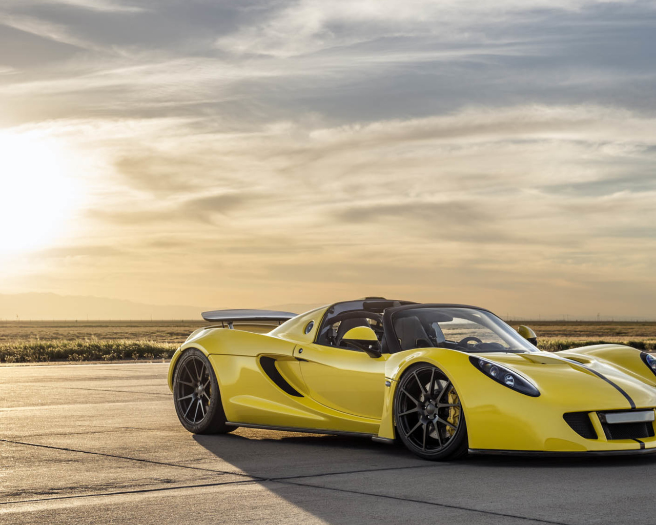 Автомобиль Hennessey Venom GT на фоне солнца в небе