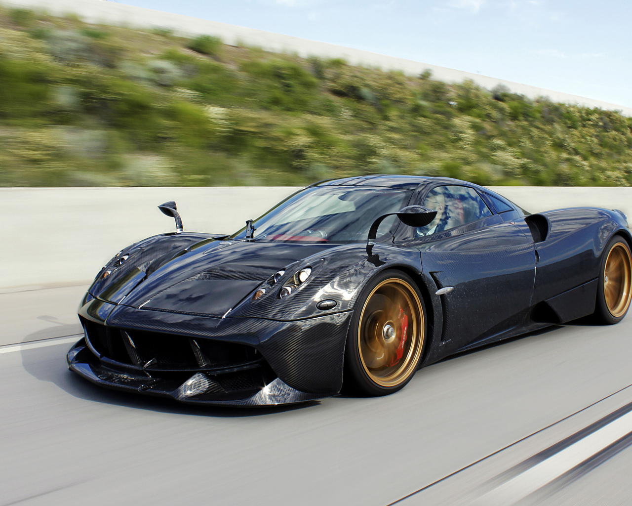 Черный спортивный автомобиль Pagani Huayra на трассе 