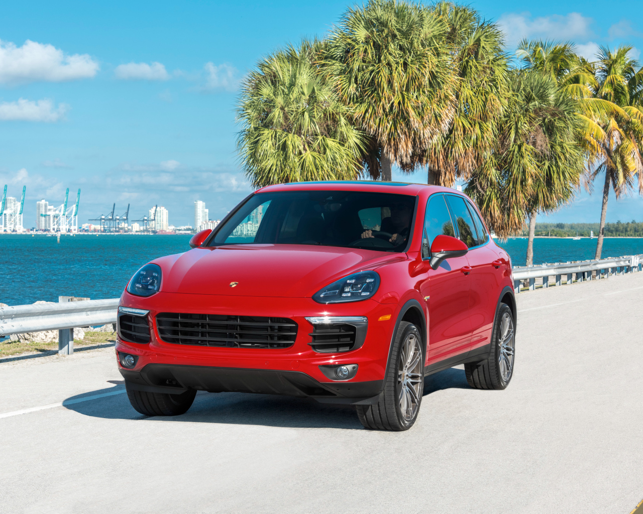 Красный внедорожник Porsche Cayenne на фоне океана