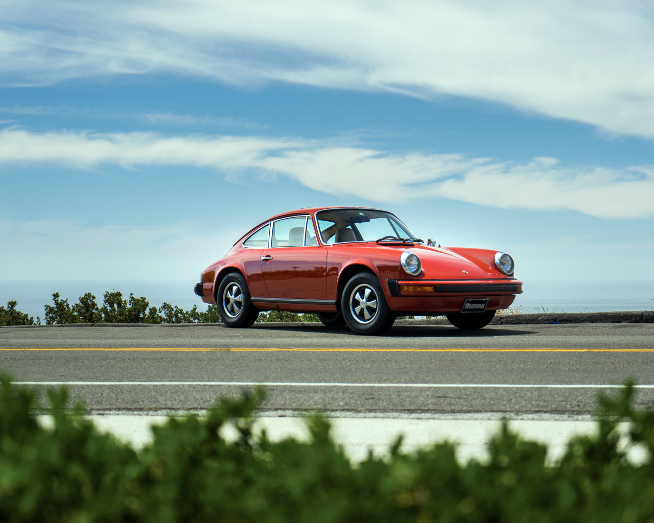 Красный автомобиль Porsche 912 на фоне голубого неба 