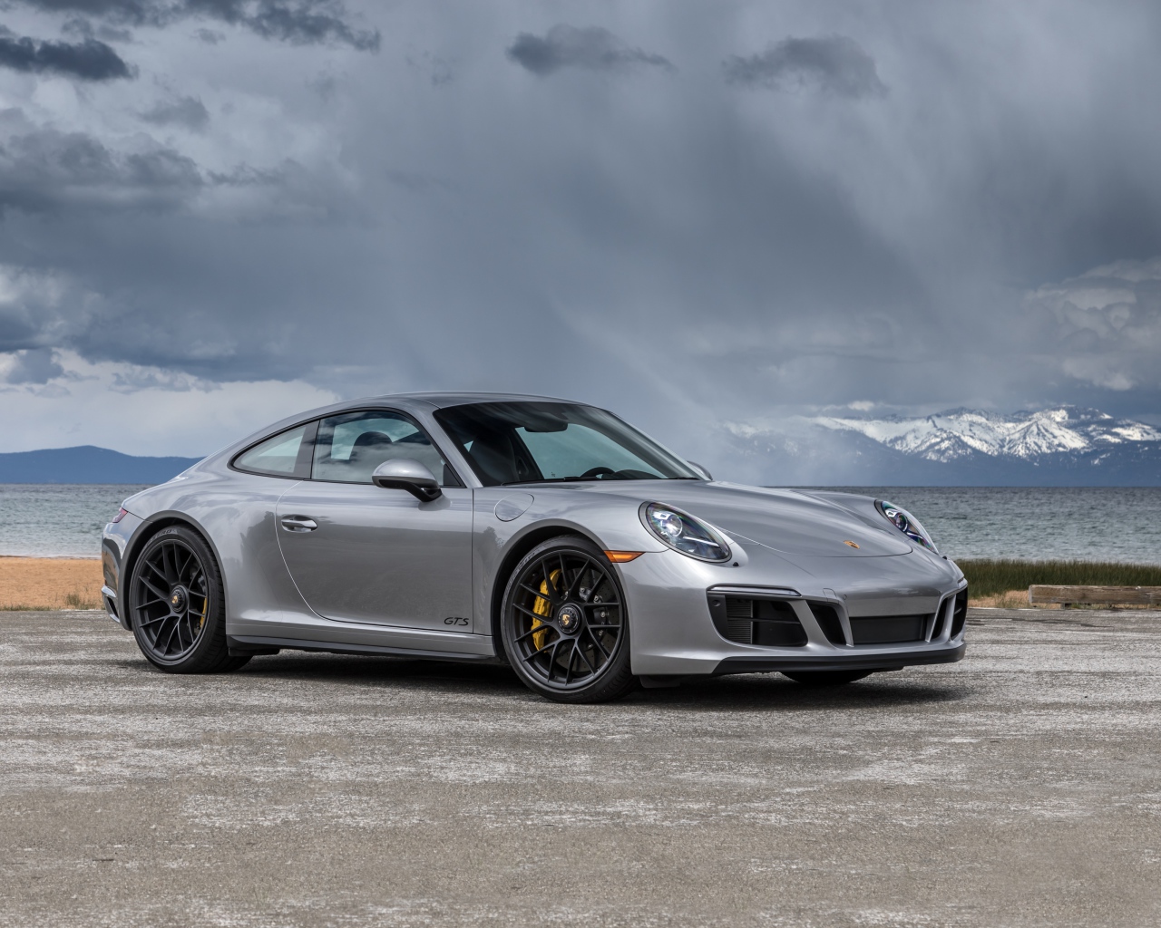 Серебристый автомобиль Porsche 911 Carrera 4 GTS Coupe на фоне грозового неба