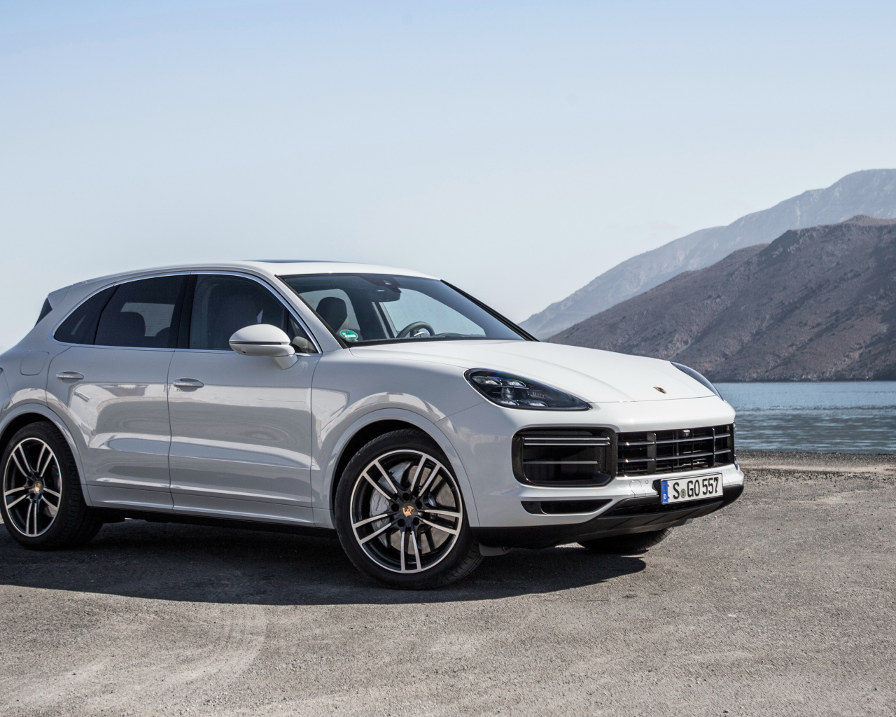 Белый автомобиль Porsche Cayenne Turbo, 2018 у воды