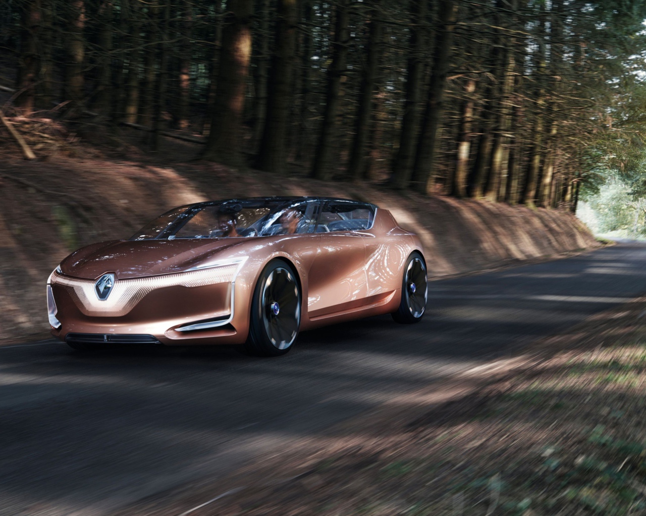 Коричневый электромобиль  Renault Symbioz на дороге в лесу