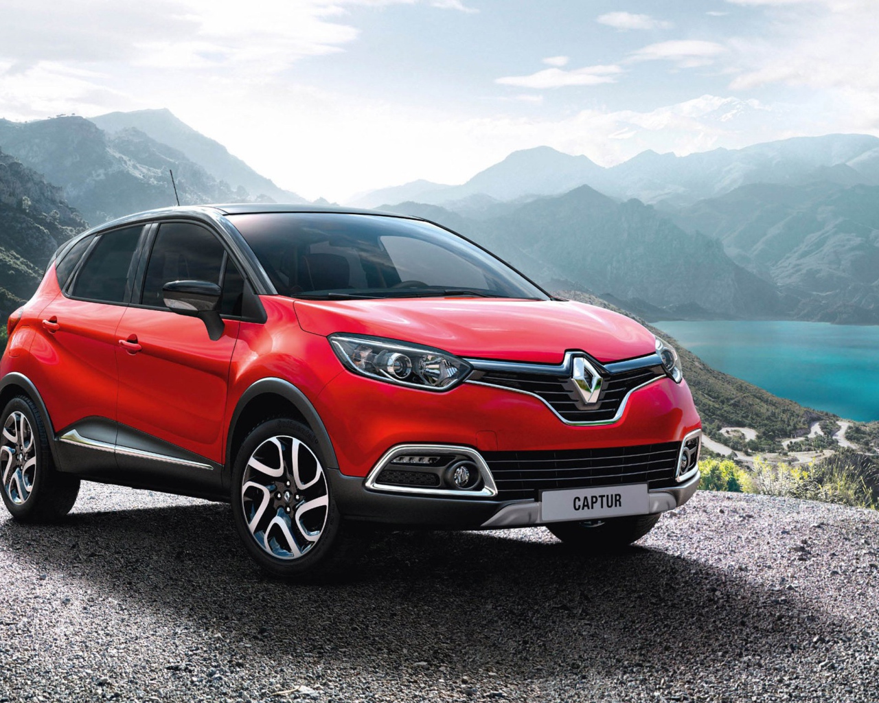Красный автомобиль внедорожник Renault Captur на фоне гор
