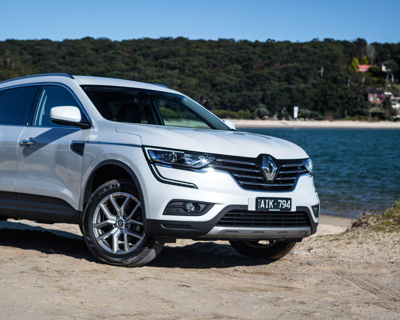 Белый автомобиль Renault Koleos у водоема