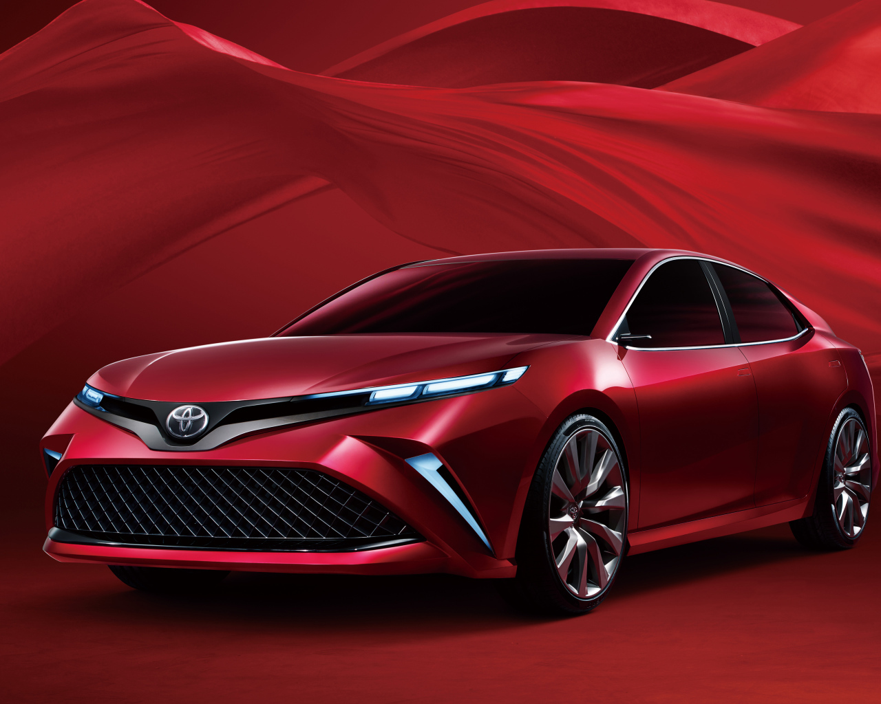 Красный автомобиль Toyota Camry, 2017 года на красном фоне 