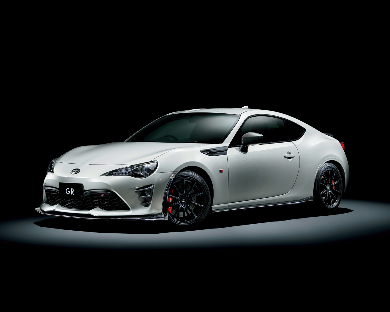 Белый спортивный автомобиль Toyota 86 GR на черном фоне