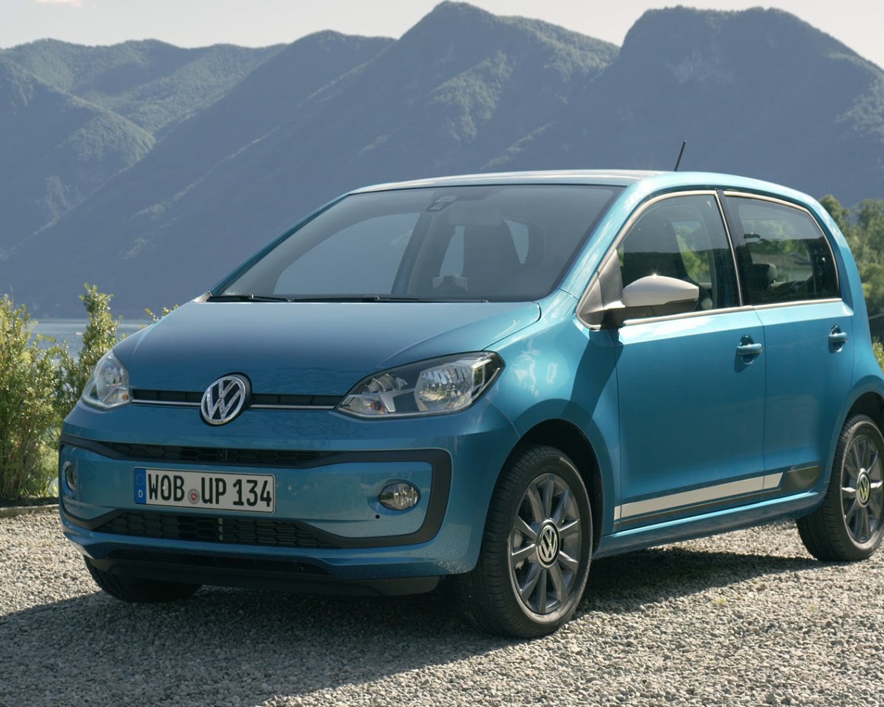 Синий Volkswagen Up 2017 года на фоне гор 