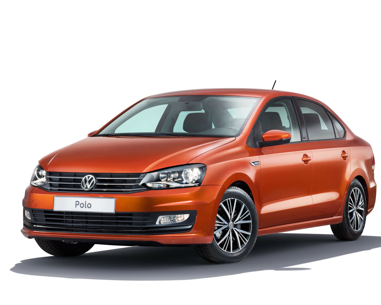 Оранжевый автомобиль Volkswagen Polo на белом фоне