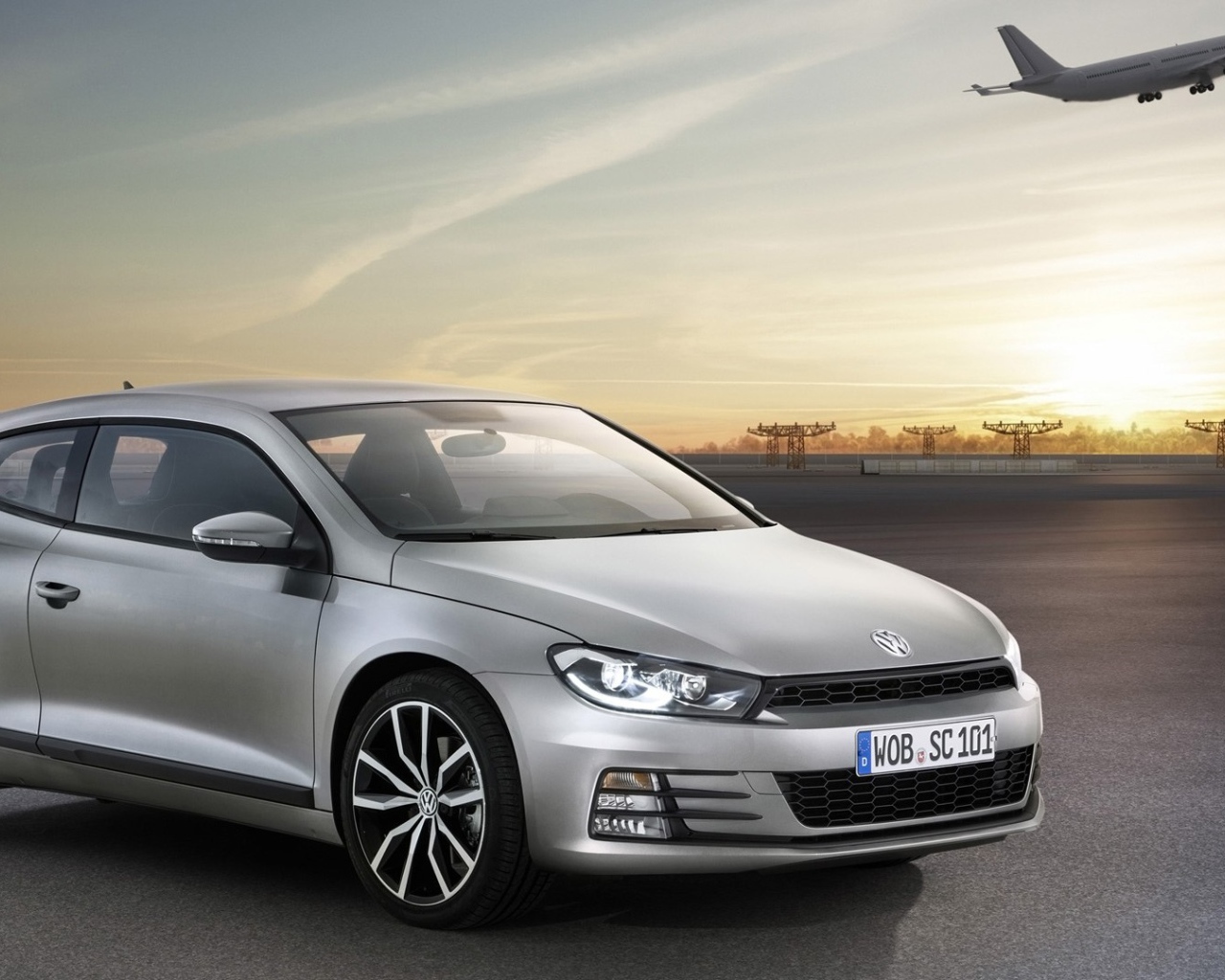 Серебристый Volkswagen Scirocco 2017 года на фоне взлетной полосы 