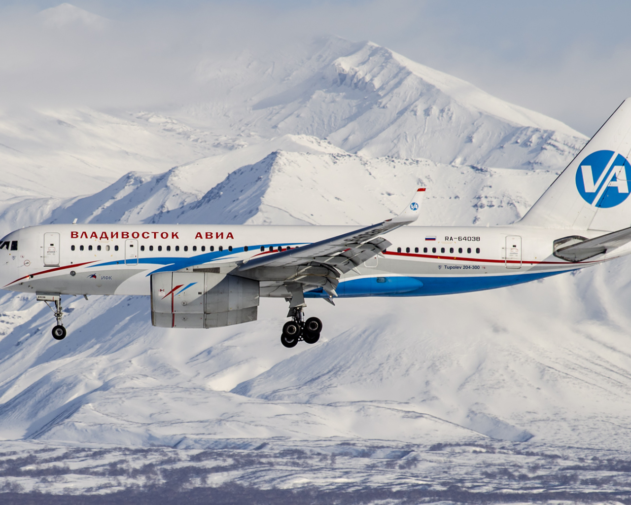 Самолет ТУ 204-300 авиакомпании Владивосток Авиа пролетает над горами Алтая 