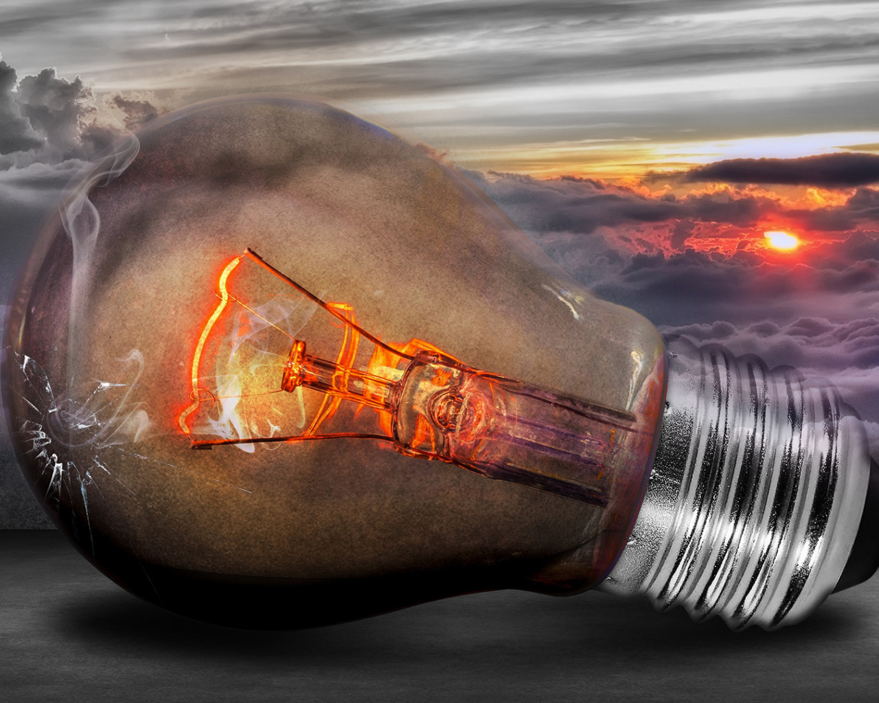 Раскаленная лампочка на фоне белых облаков в небе