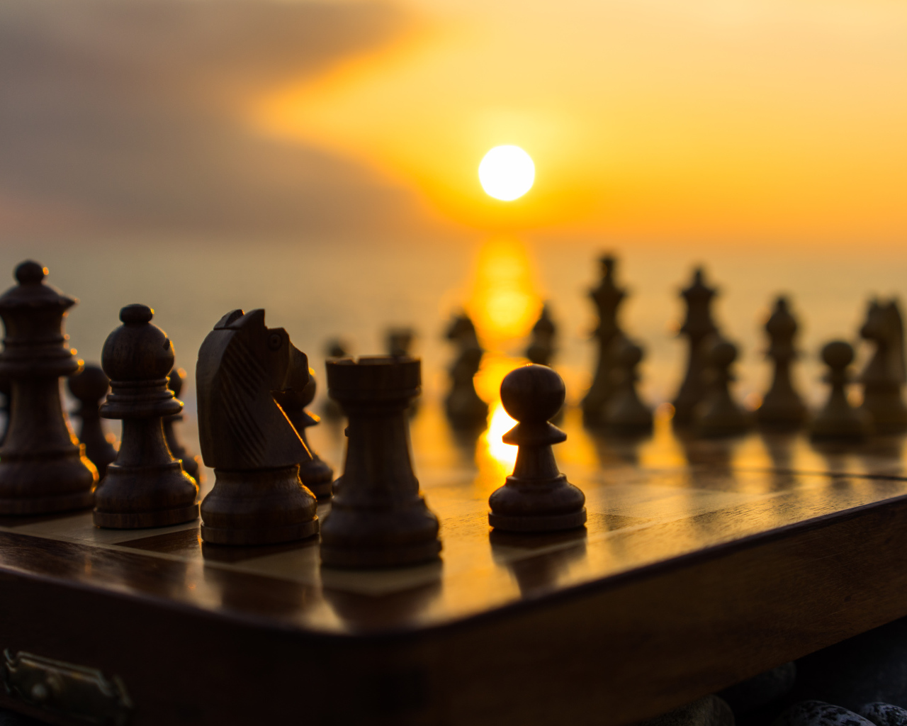 Шахматная доска с шахматными фигурами на закате солнца