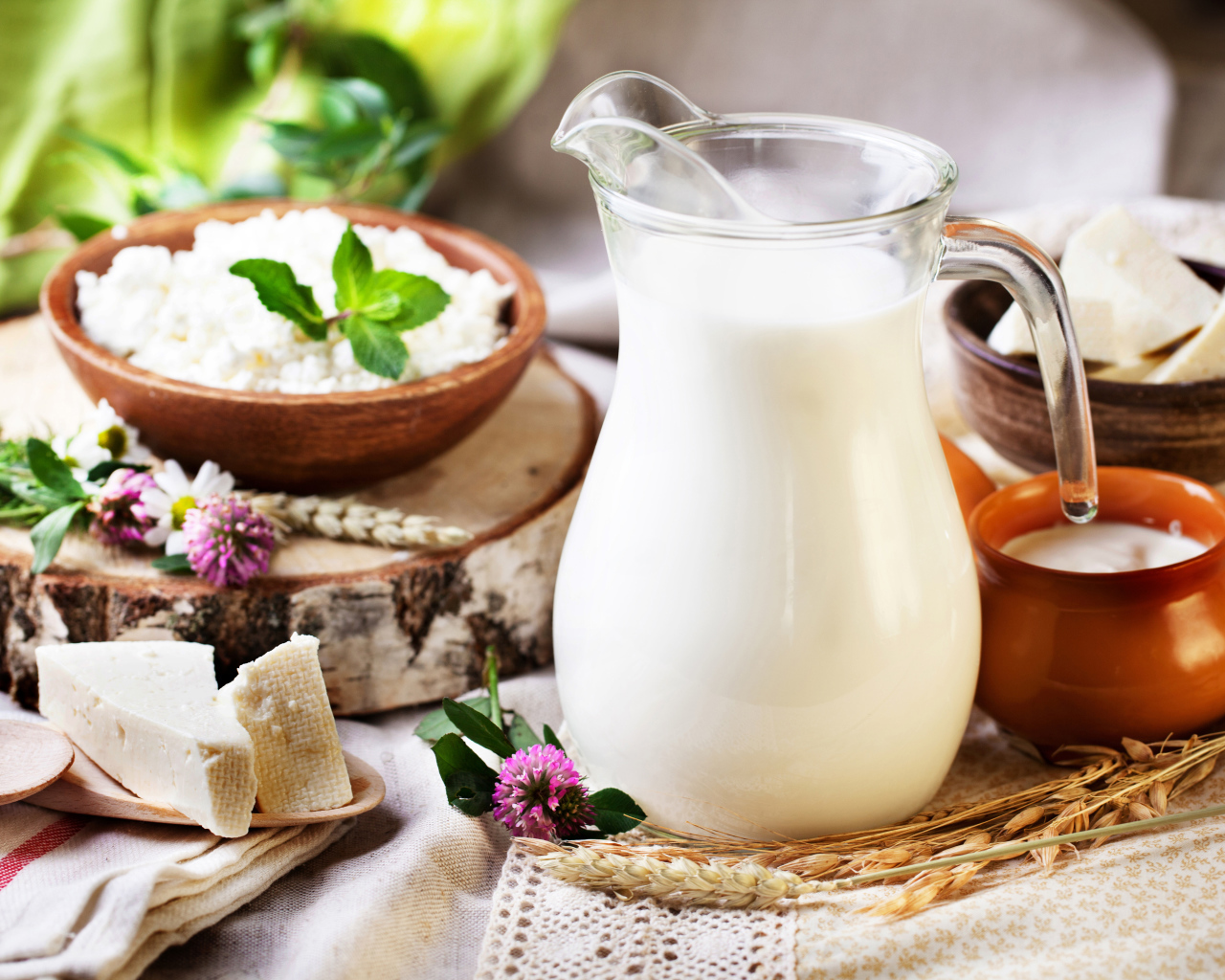 Кувшин со свежим молоком и сыр на столе