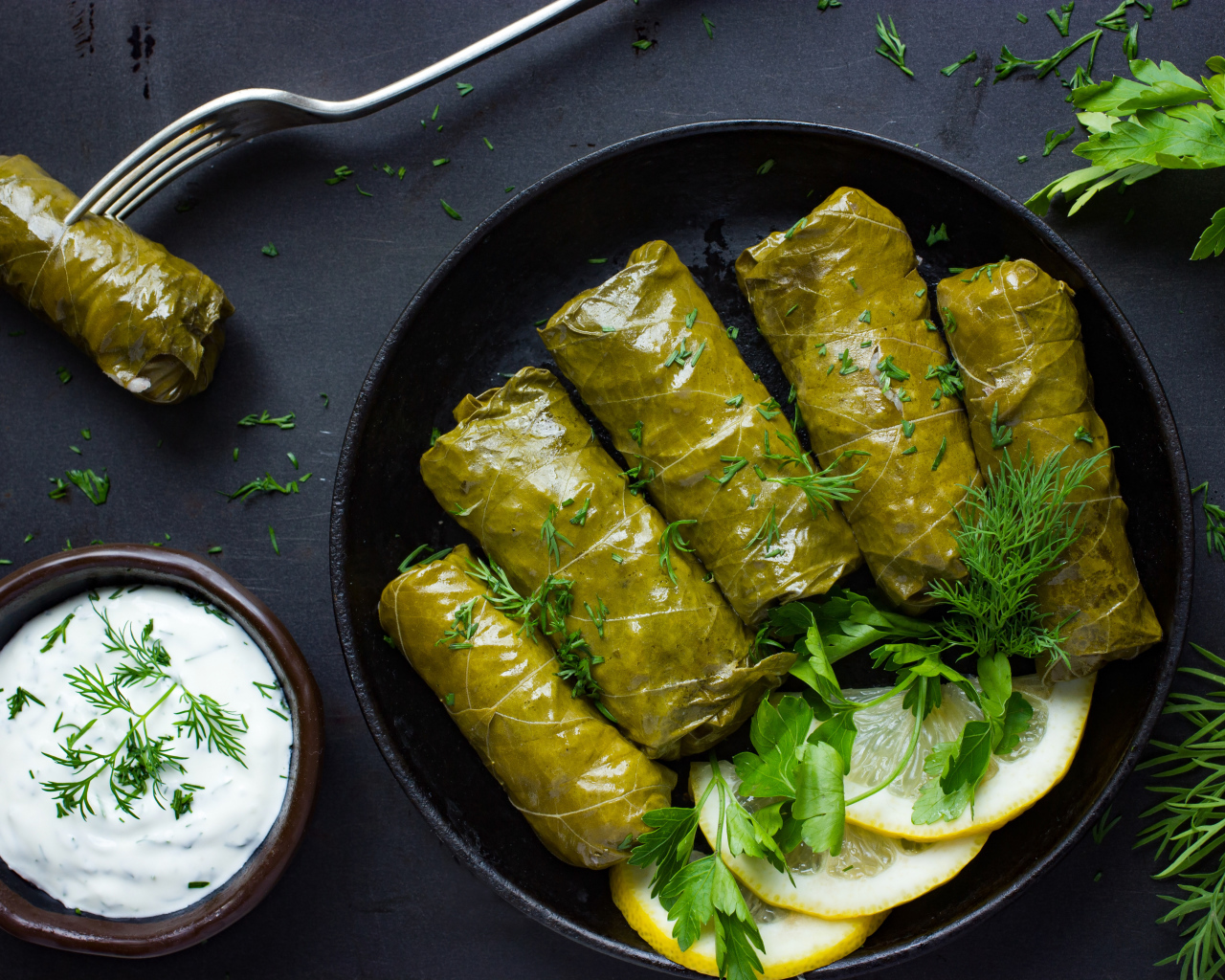 Аппетитная долма с кусочками лимона на столе 