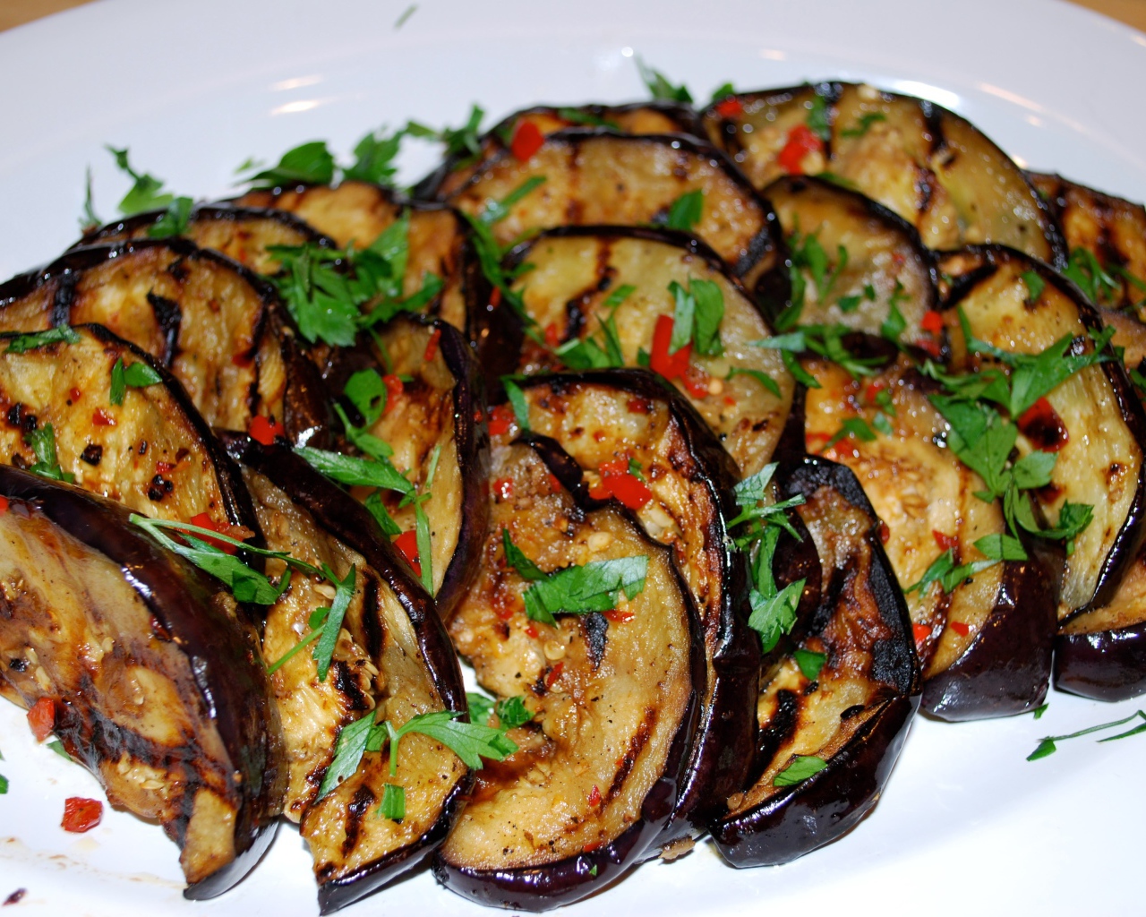 Аппетитные жареные баклажаны на тарелке с зеленью