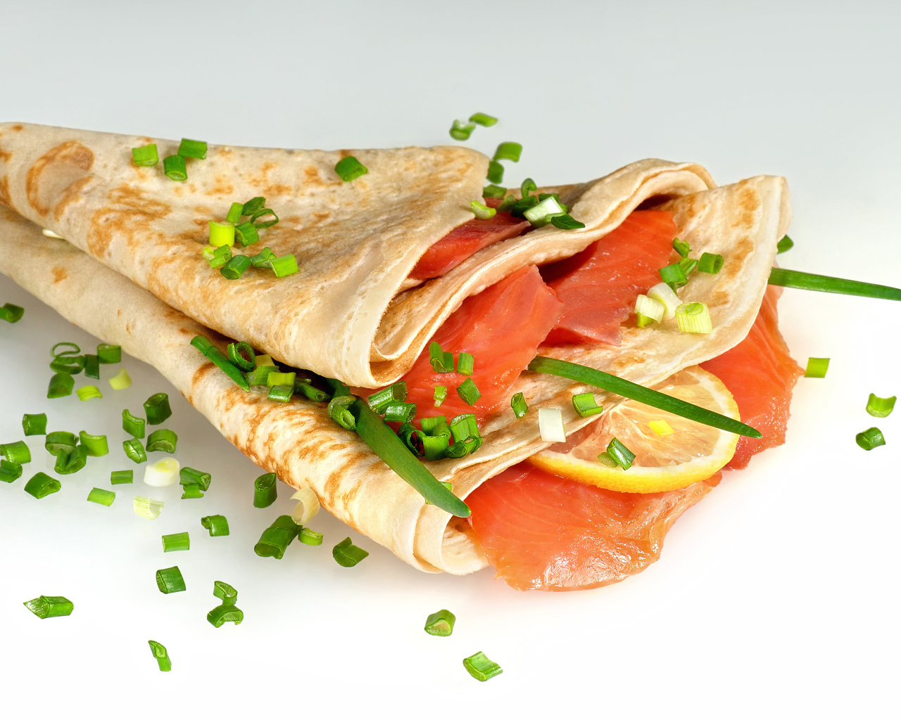 Аппетитный блин с красной рыбой и зеленым луком