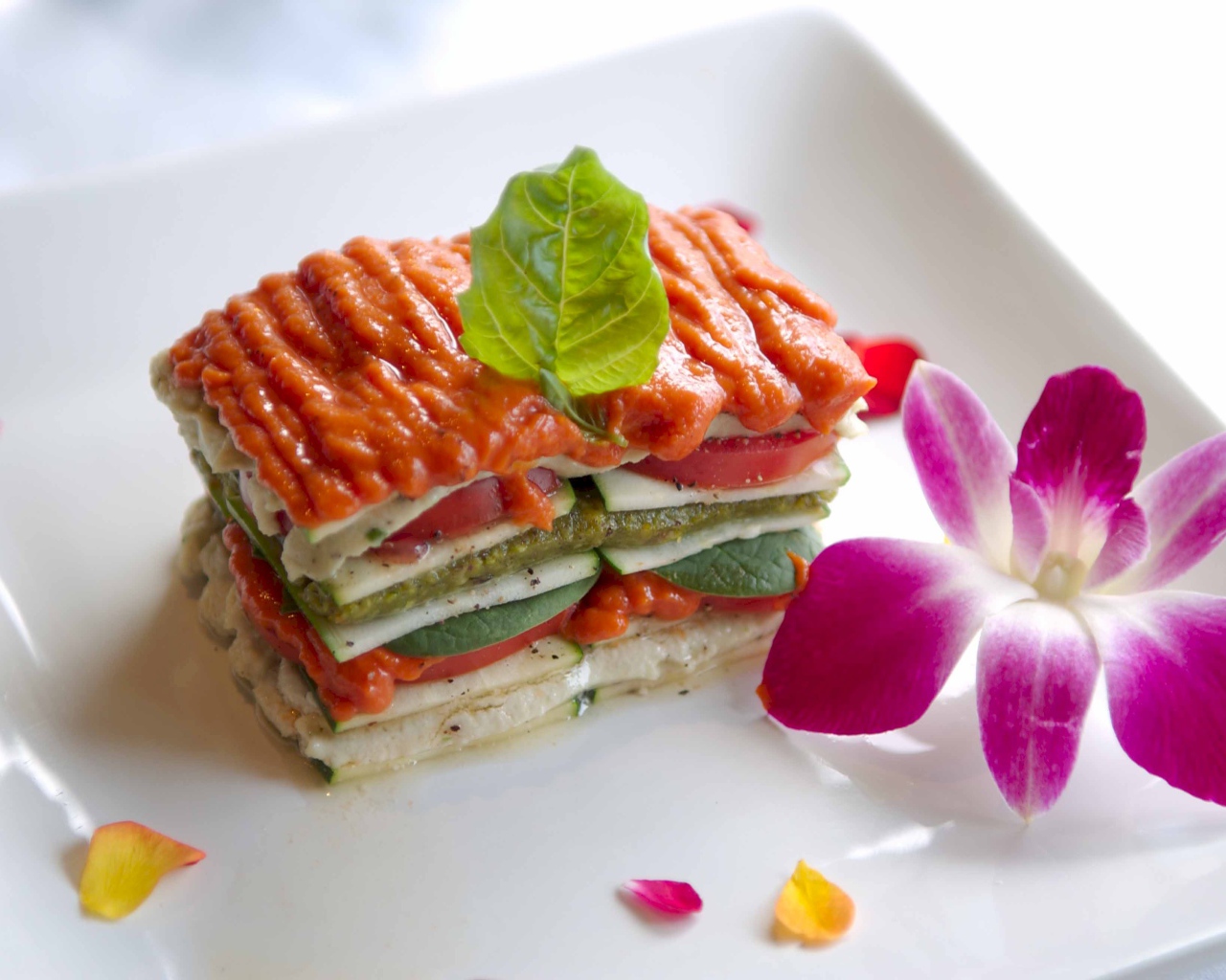 Аппетитный овощной бутерброд на белой тарелке с цветком
