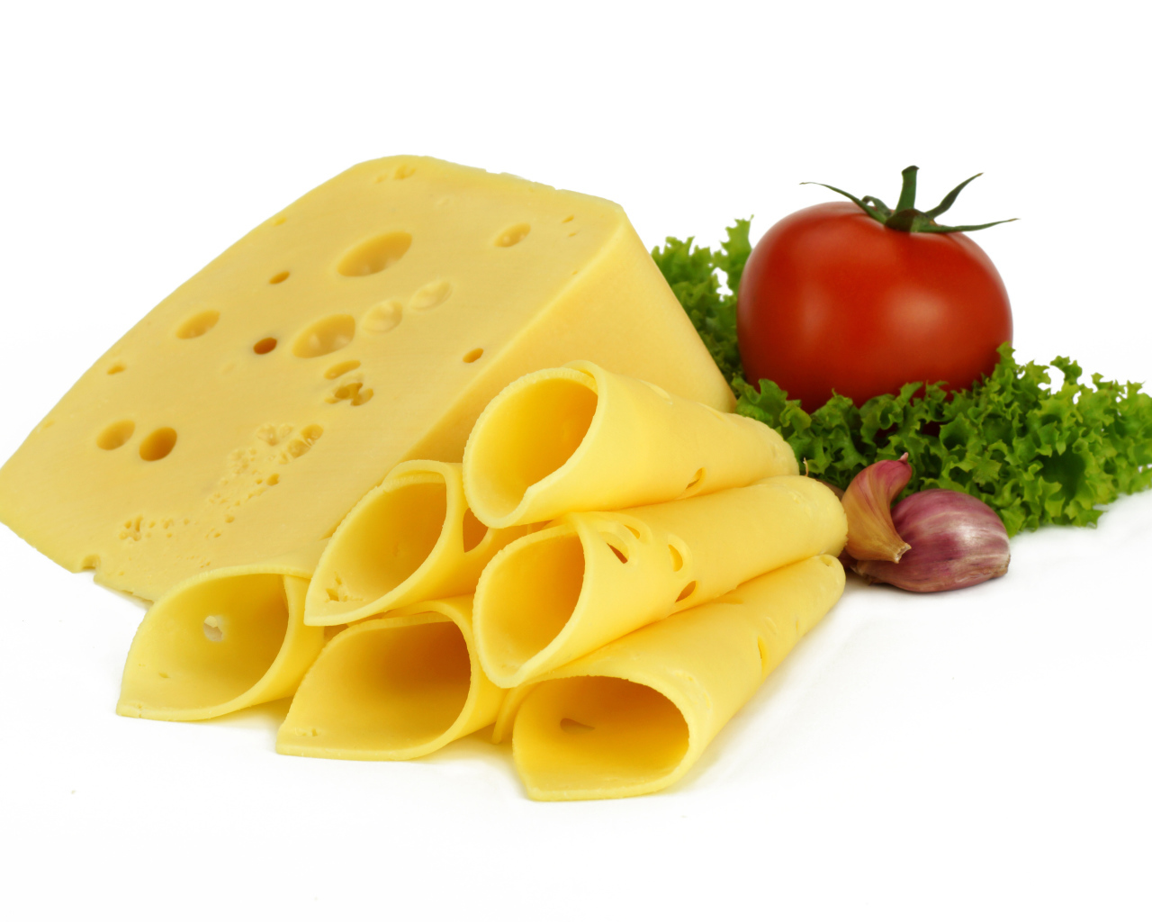 Сырная нарезка с помидором, листьями салата и чесноком на белом фоне