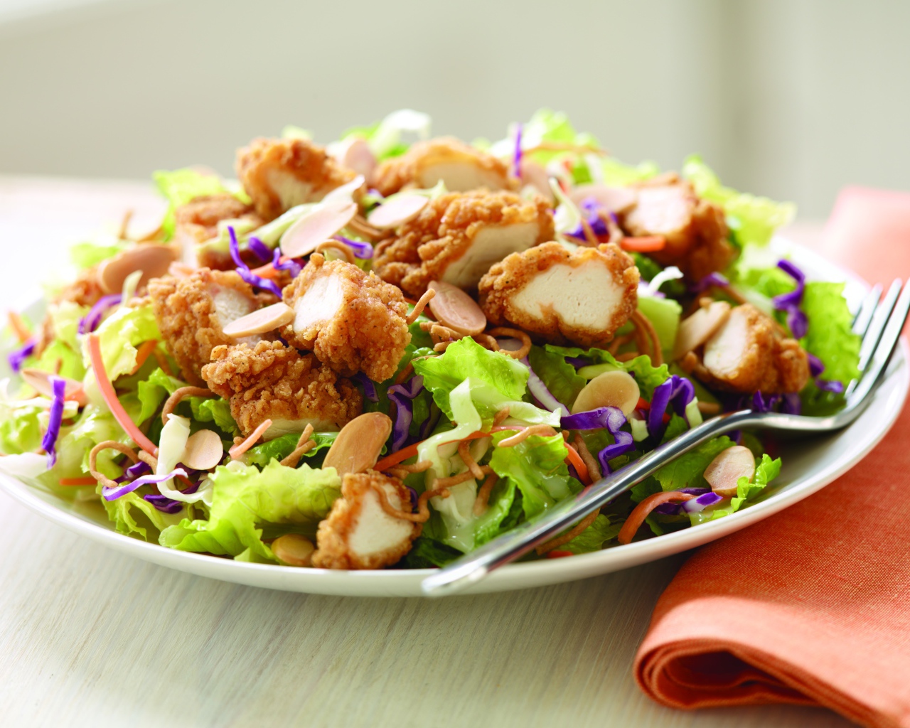 Куриный салат с орехами и капустой на тарелке
