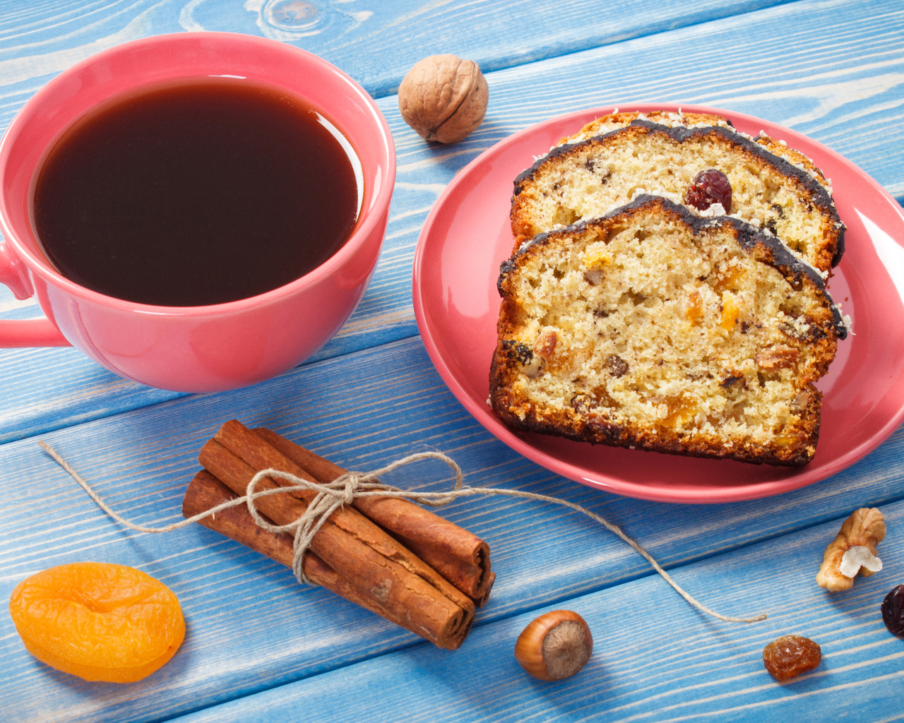 Кекс с корицей, орехами и курагой на столе с чашкой чая
