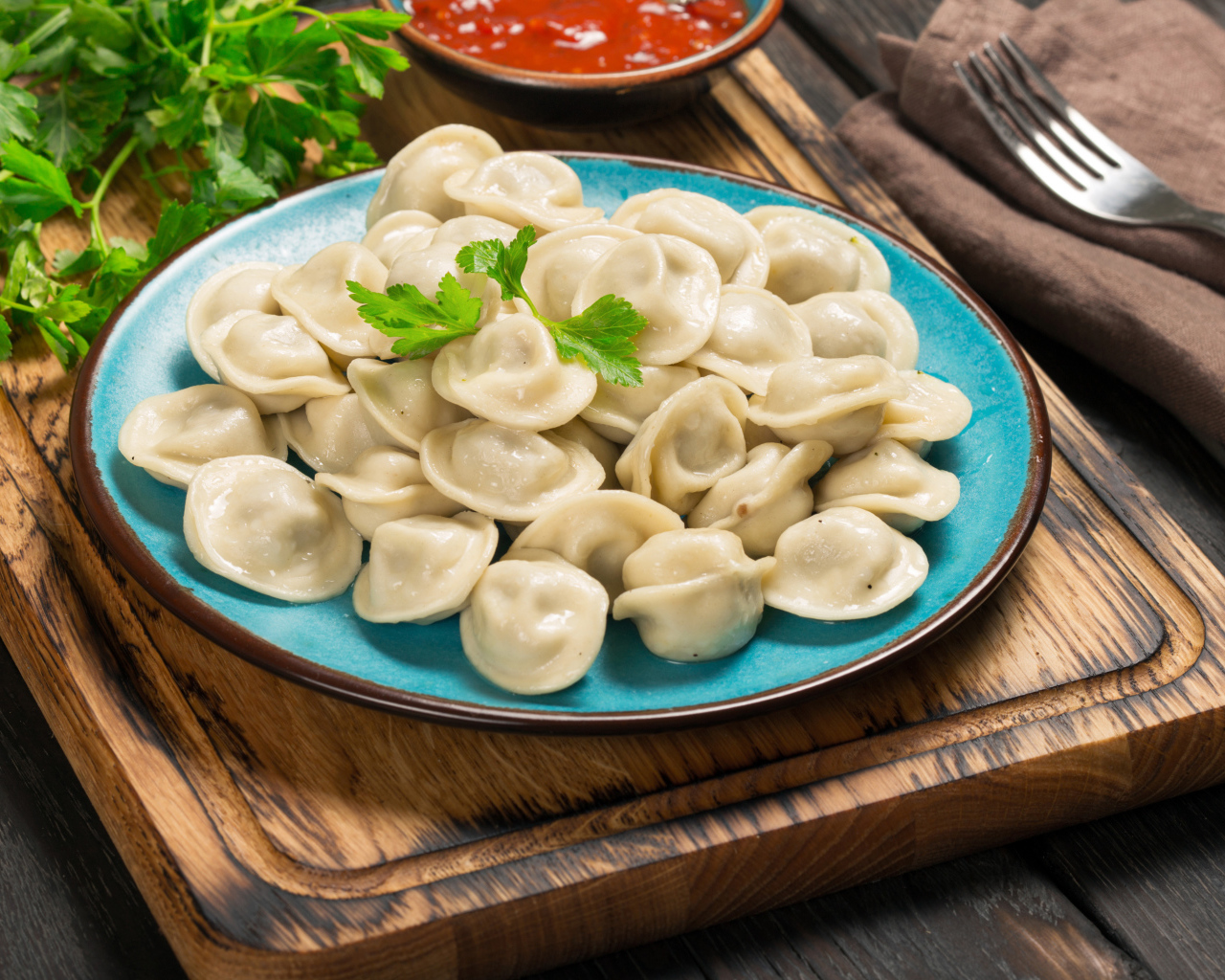 Вкусные пельмени на голубой тарелке 