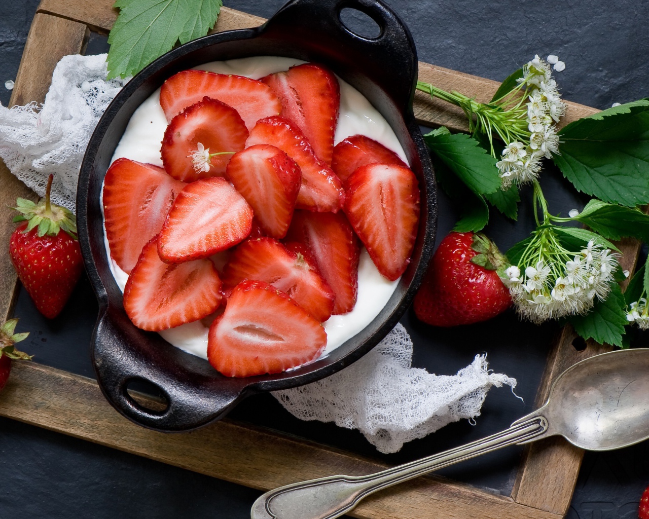 Свежая клубника с йогуртом на завтрак на столе с белым цветком