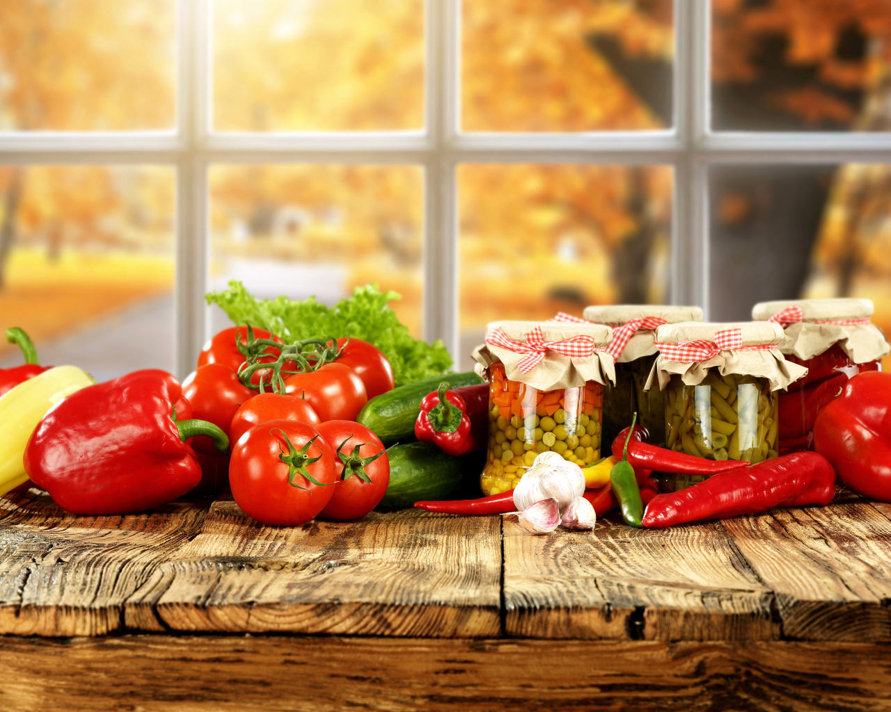 Свежие овощи и зимние заготовки на столе 