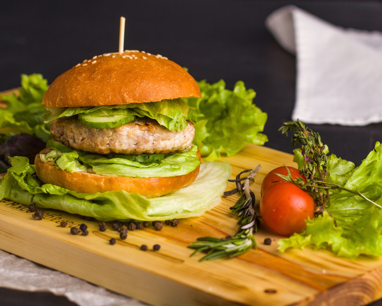 Гамбургер с зеленью на разделочной доске  