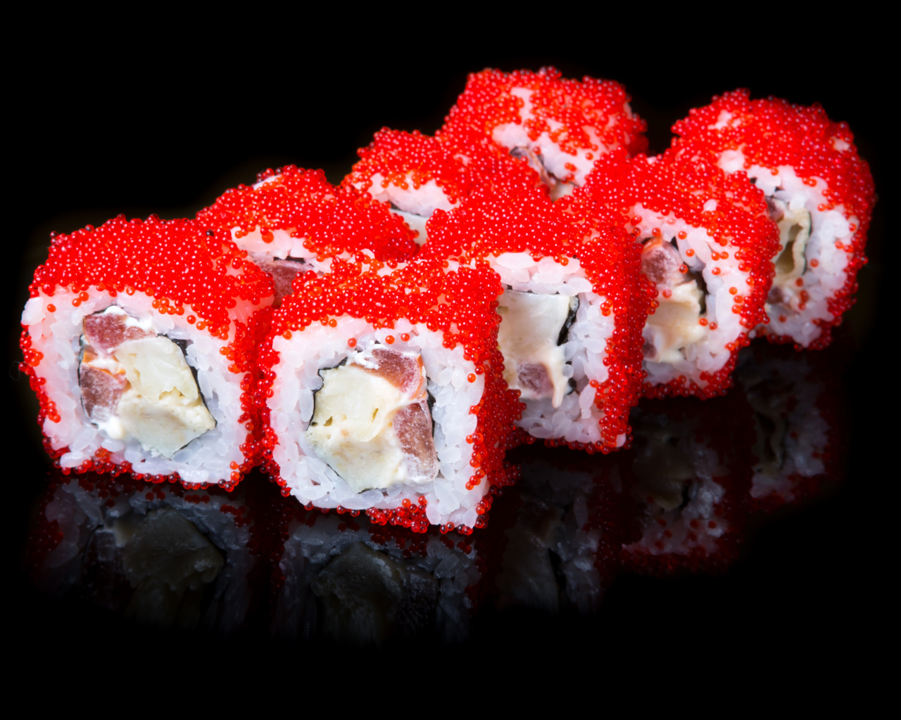 Японские роллы с красной икрой на черном фоне 