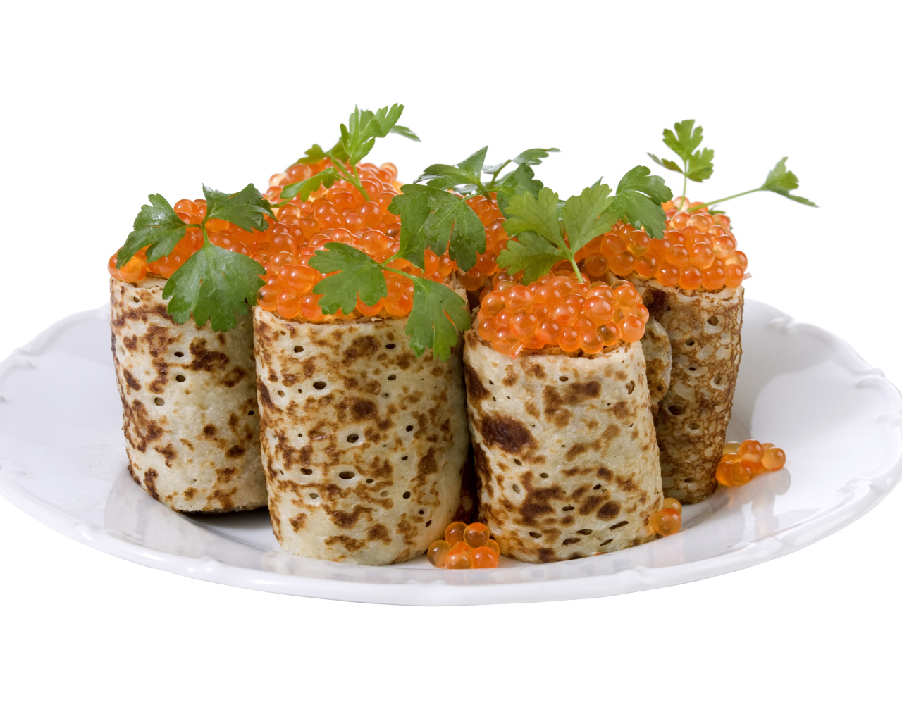 Роллы из блинов с красной икрой на белом блюде