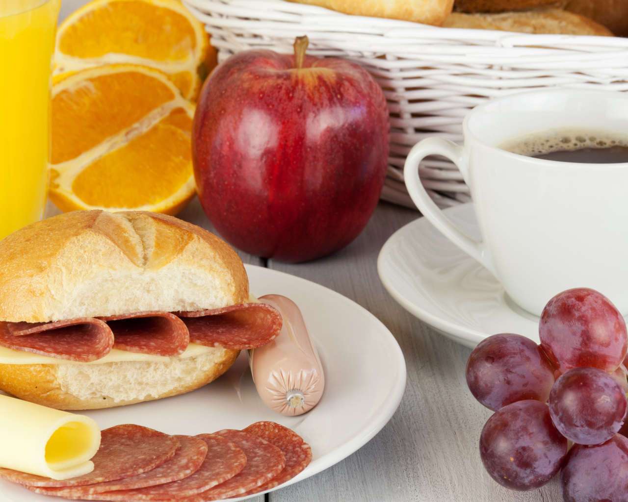 Бутерброд с сыром и колбасой и сок с яблоком и виноградом на завтрак