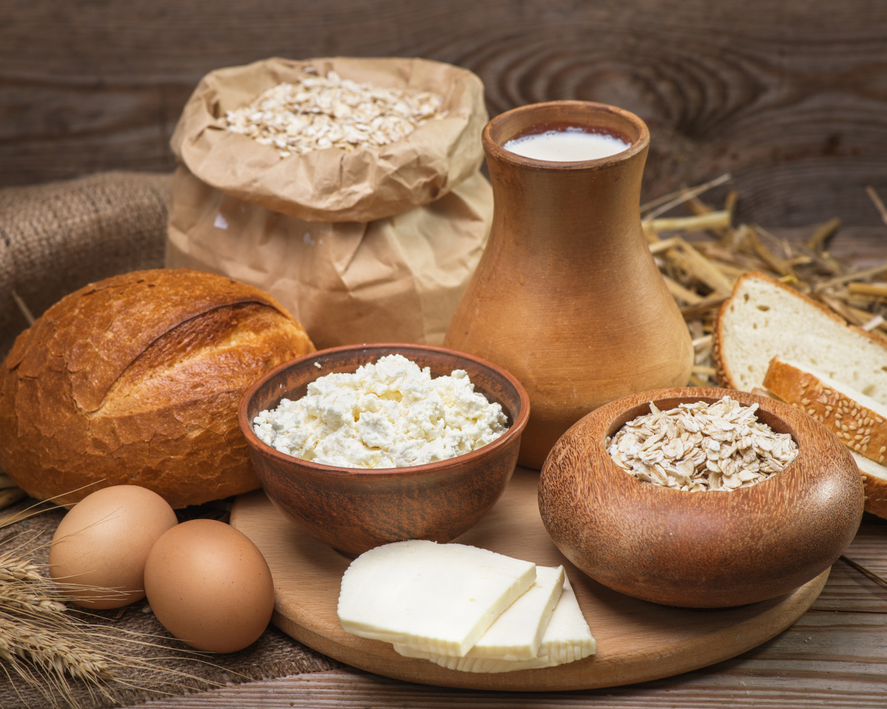 Натюрморт сыр, хлеб, яйца и молоко на столе 