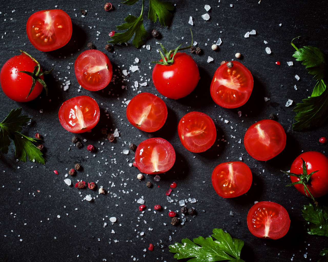 Помидоры на столе с зеленью петрушки и специями