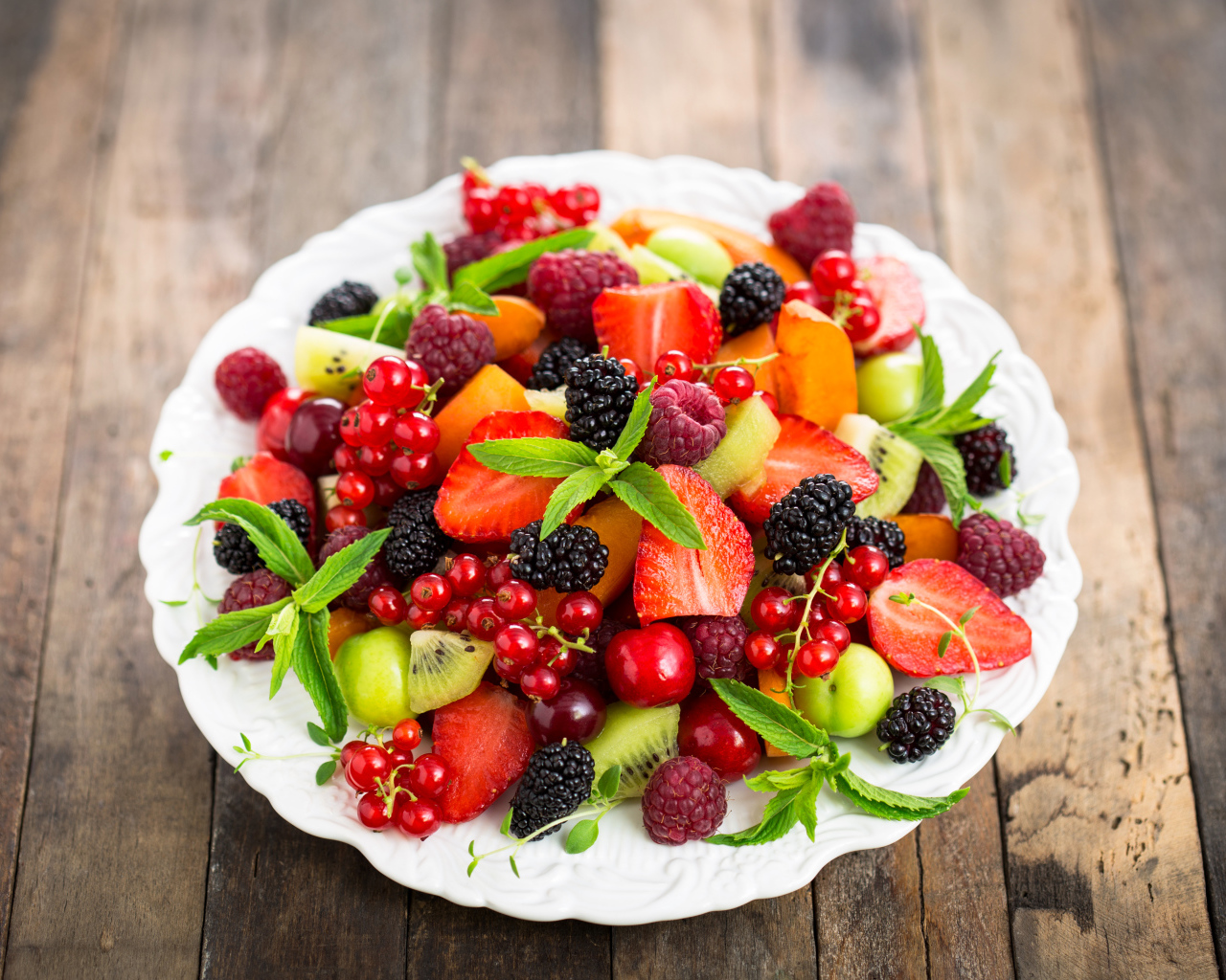 Аппетитные свежие фрукты на белой тарелке 