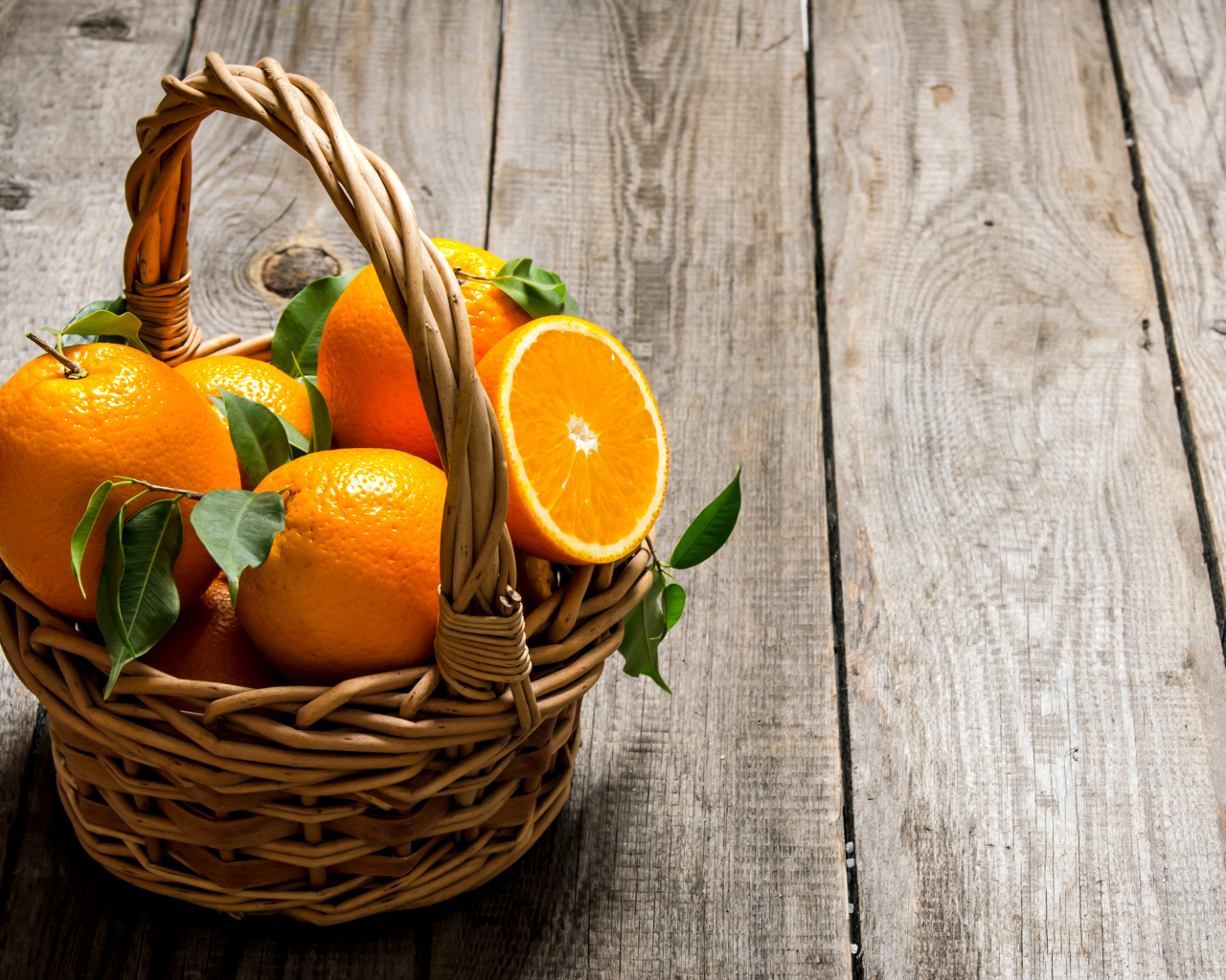 Корзина с апельсинами на деревянном столе