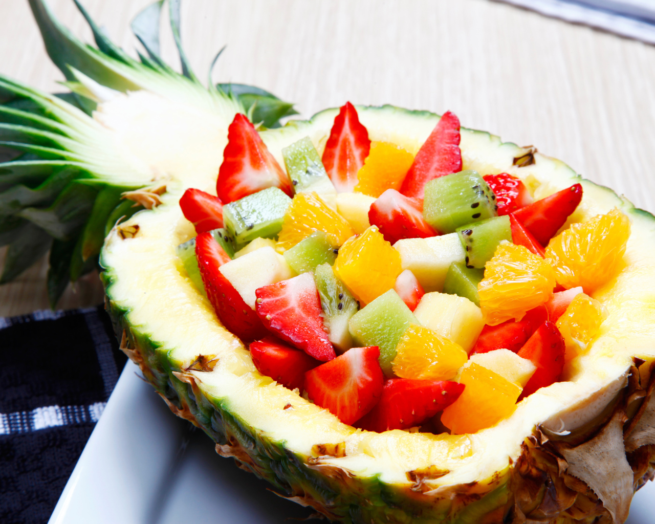 Фруктовый салат из цитрусовых  в тарелке из свежего ананаса 