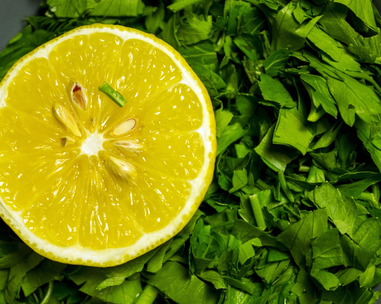 Половина желтого лимона с зеленью петрушки