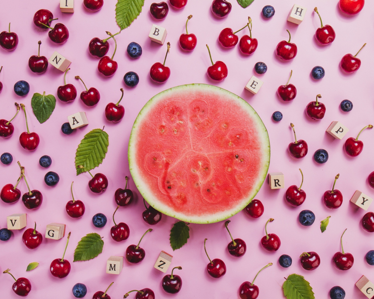 Половина арбуза с ягодами вишни и черники на столе