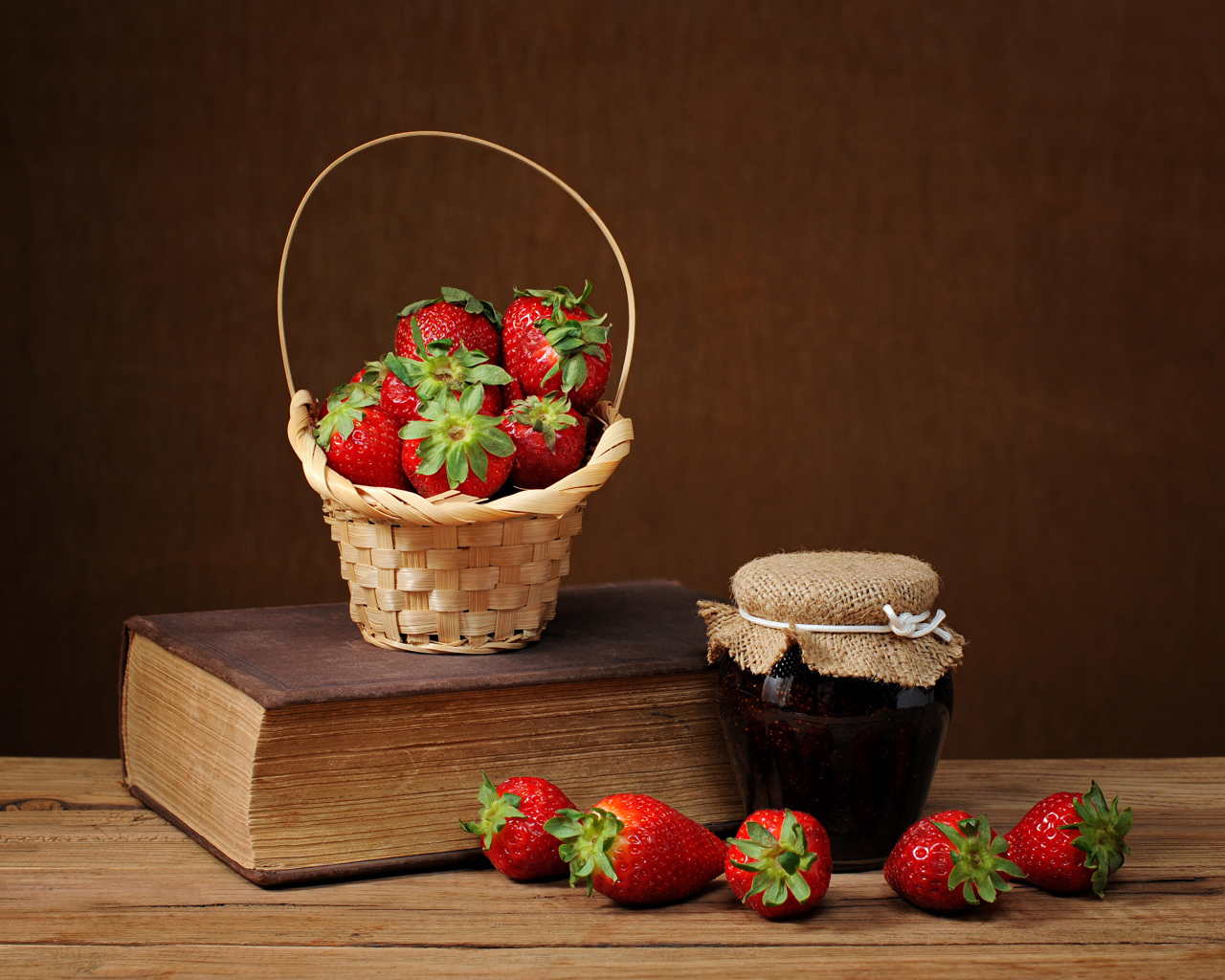 Клубничный джем, свежая клубника и книга на столе