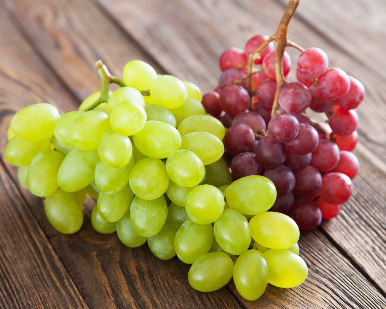 Две грозди белого и розового винограда на столе