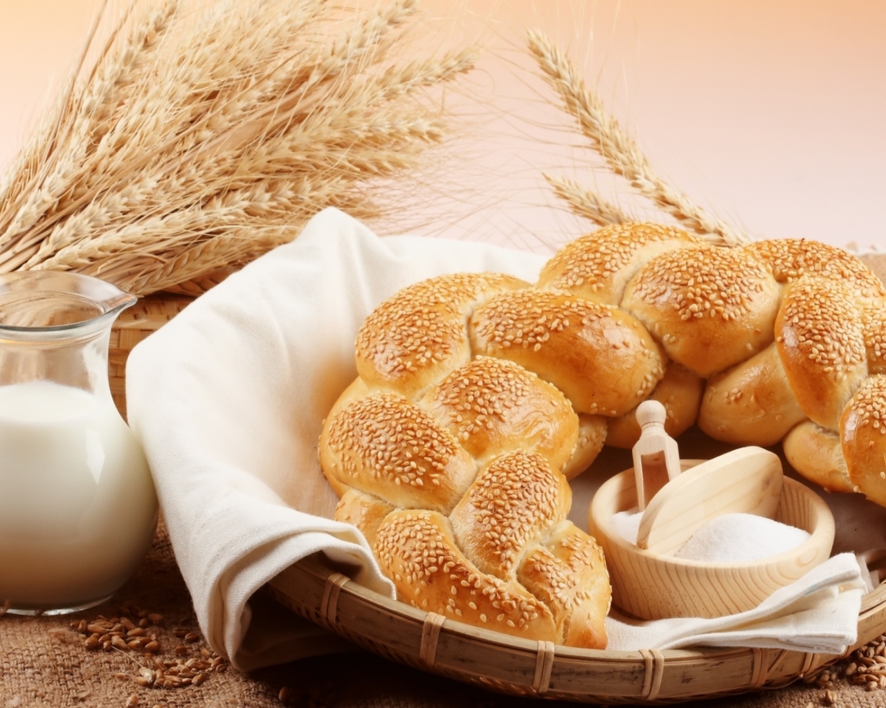 Хлебобулочное изделие и кувшин молока на столе