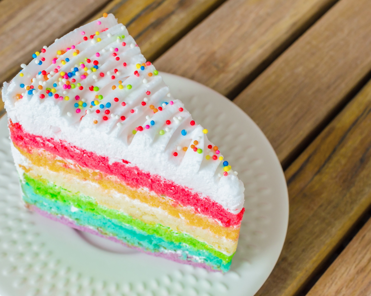 Кусок разноцветного торта на белой тарелке