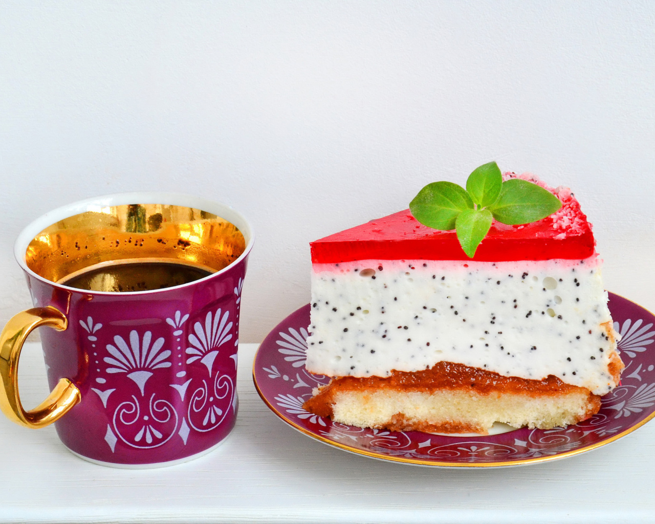 Кусок пирожного на тарелке с чашкой чая