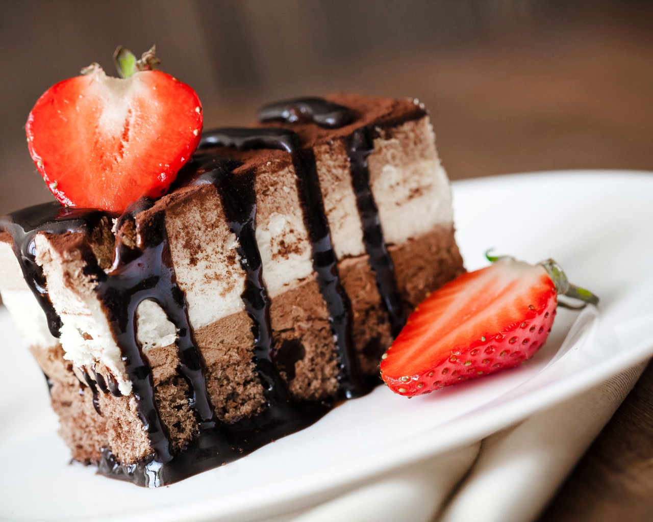 Кусок шоколадного пирожного со свежей клубникой