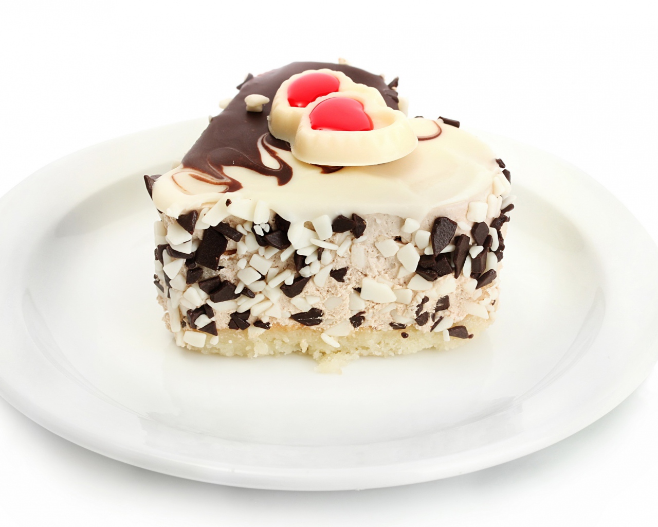 Аппетитное пирожное в форме сердца с шоколадом на белой тарелке